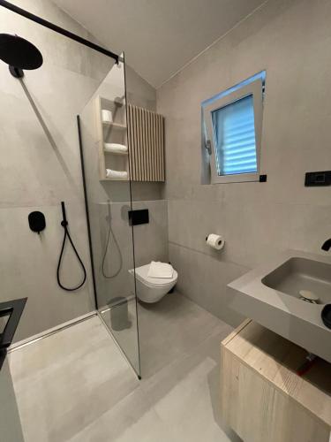 ein Bad mit einer Dusche, einem WC und einem Waschbecken in der Unterkunft STARA GAVZA - bungalows , apartments in Cres