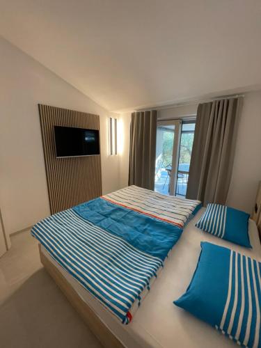 1 Schlafzimmer mit 2 Betten und einem Fenster in der Unterkunft STARA GAVZA - bungalows , apartments in Cres
