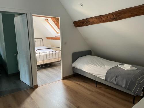 une petite chambre avec un lit et un miroir dans l'établissement La Maison de Zoé, à Saint-Denis-sur-Loire