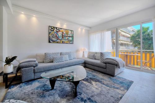 a living room with a couch and a table at Cannes Luxury Rental - Stunning renovated 2 bedroom apartment in Cannes