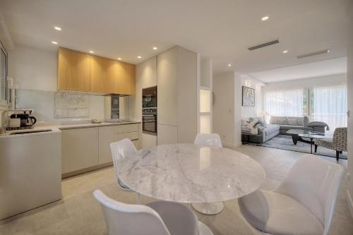 a kitchen and living room with a table and chairs at Cannes Luxury Rental - Stunning renovated 2 bedroom apartment in Cannes