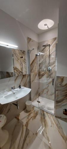 uma casa de banho com um lavatório e um chuveiro em Perugia Plaza Hotel em Perugia