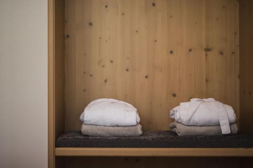 dos toallas sentadas en un estante en una pared de madera en Vierbrunnenhof, en Anterselva di Mezzo