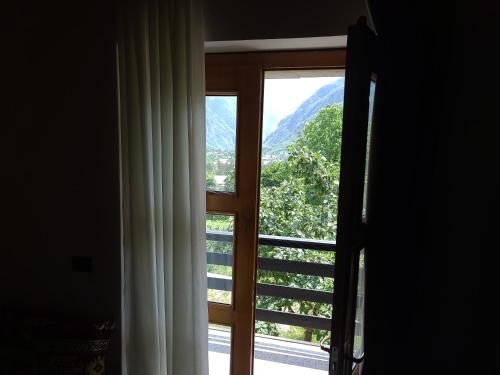 a window with a view of a mountain at Villa Gjeçaj Guesthouse and Restaurant in Theth