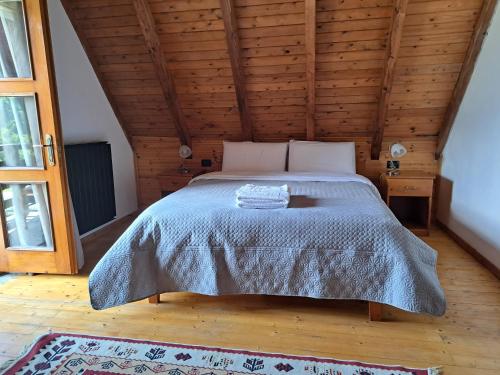 a bed in a room with a wooden ceiling at Villa Gjeçaj Guesthouse and Restaurant in Theth