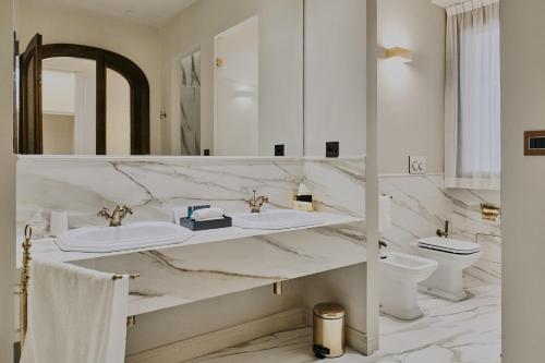 a white bathroom with two sinks and a mirror at Villa Lena Puglia in Oria