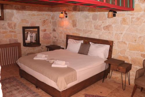 a bedroom with a bed in a stone wall at Casa Di Cappadocia in Uchisar