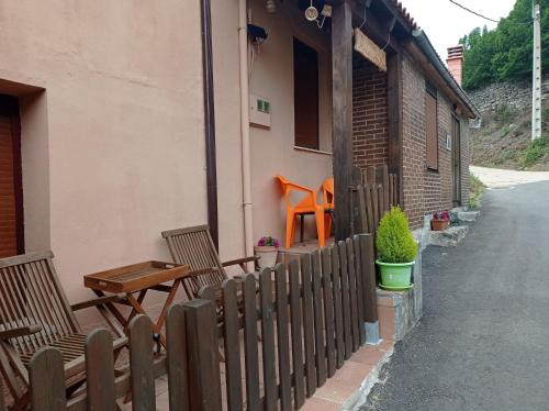 a wooden fence with two chairs and a table at Casa Manuel y Ana María. in Llombera