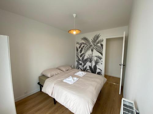 ein kleines Schlafzimmer mit einem Bett mit weißer Bettwäsche in der Unterkunft La Coloc' - Centre ville - Gare in Saint-Brieuc