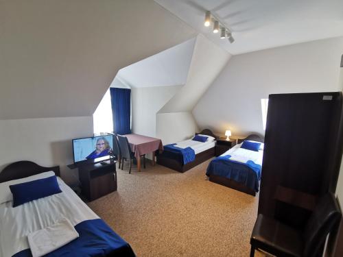 a room with two beds and a flat screen tv at SAS rooms & restaurant in Długie