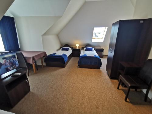 a hotel room with two beds and a flat screen tv at SAS rooms & restaurant in Lublin