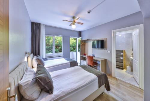 1 dormitorio con 2 camas y ventana en Palmada Hotel en Sakarya