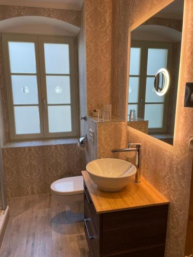 uma casa de banho com um lavatório, um WC e um espelho. em Honigmond Boutique Hotel em Berlim