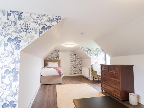 - une chambre dotée d'un lit avec du papier peint bleu et blanc dans l'établissement Challenger Lodge, à Lairg