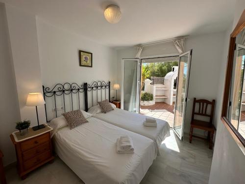 ネルハにあるSpacious family villa Aljamar 8aのベッドルーム(大きな白いベッド1台付)、パティオが備わります。