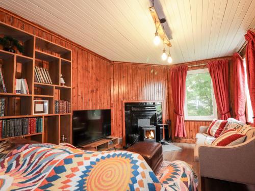 a living room with a couch and a fireplace at Challenger Bothy in Lairg