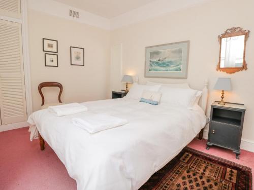 a white bed with two pillows on it in a bedroom at 29b Lower Street in Dartmouth