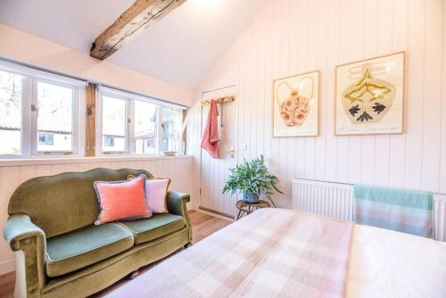 a bedroom with a bed and a couch and windows at The Studio, Hoo in Woodbridge