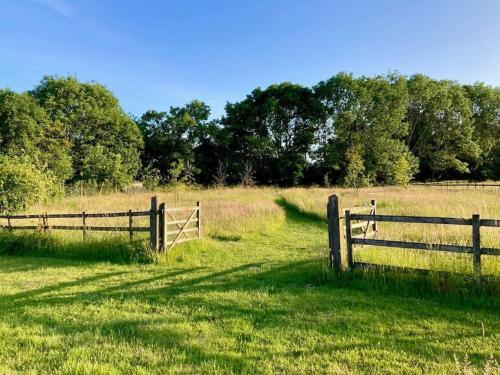 a fence in the middle of a field at The Studio, Hoo in Woodbridge