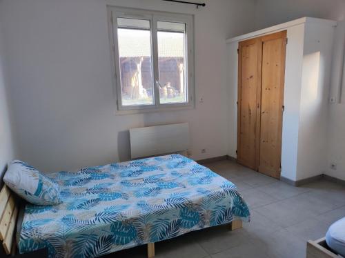 een slaapkamer met een bed, een raam en een deur bij appartement dans partie de mas en camargue in Arles
