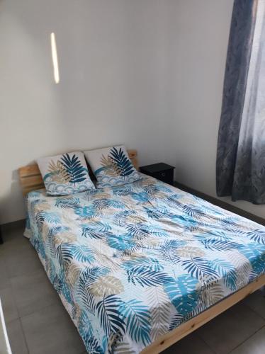 ein Bett mit einer blauen und weißen Bettdecke in einem Schlafzimmer in der Unterkunft appartement dans partie de mas en camargue in Arles