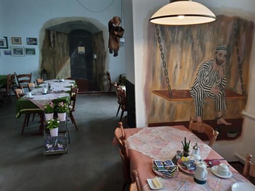 a dining room with tables and a painting of a man at Zum Amtsrichter in Hillesheim