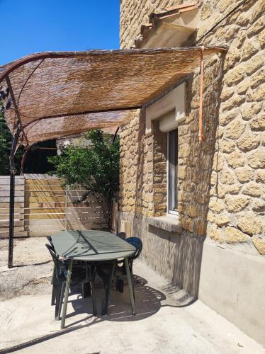 - une table de pique-nique devant un bâtiment en pierre dans l'établissement appartement dans partie de mas en camargue, à Arles