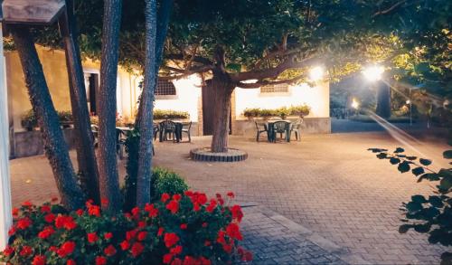 a courtyard with tables and flowers at night at L'Antica Vigna in Randazzo