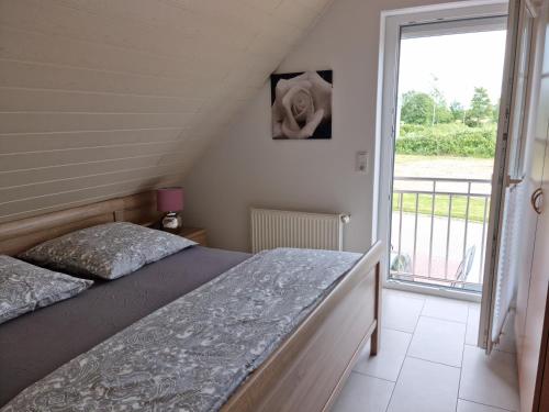 a bedroom with a bed and a large window at Windlicht im 1 Stockwerk in Norddeich