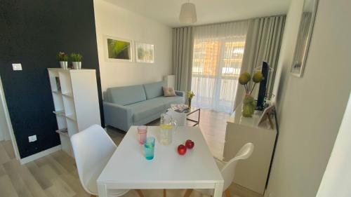 VELA MAR في كولوبرزيغ: غرفة معيشة مع طاولة وكراسي بيضاء