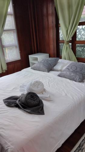 a white bed with two towels on top of it at Aran Cottage Ngamwongwan The Pool Villa in japanese Garden in Nonthaburi
