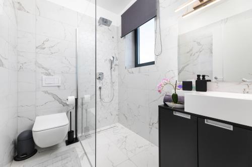 a white bathroom with a toilet and a sink at Apartment Magdalena in Malinska