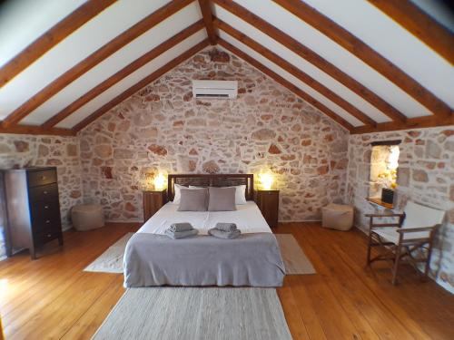 a bedroom with a bed and a stone wall at Hvar Architect's House in Pitve