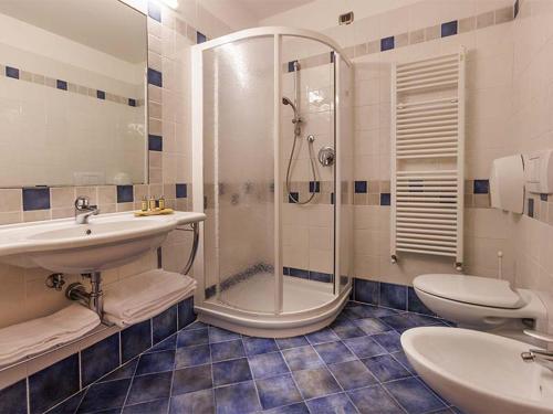 a bathroom with a shower and a sink and a toilet at Natur Resort Panorama in Malcesine