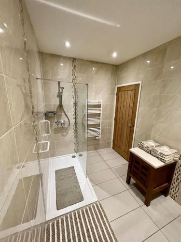 a bathroom with a shower and a tub and a sink at One Bedroom Apartment in Bangor in Bangor