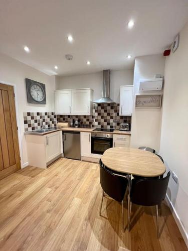 a kitchen with a table and chairs in a room at One Bedroom Apartment in Bangor in Bangor