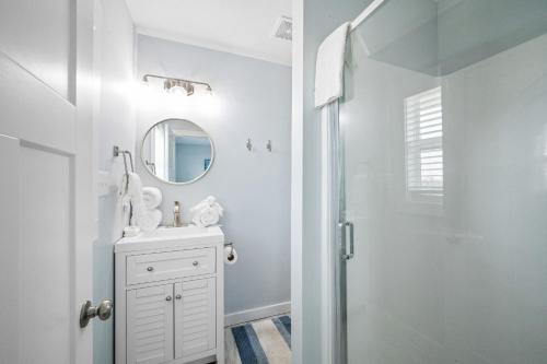a white bathroom with a sink and a mirror at Reel House in Gulf Shores
