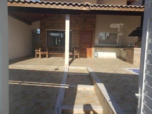 un patio con tavolo e sedie in una casa di Casa Peruibe com Piscina Mtk2 a Peruíbe