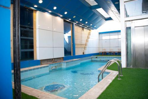 una piscina con un tobogán en un edificio en Al Nabarees Al Masi Hotel, en Yeda