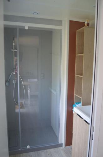 une salle de bain avec une douche avec une porte vitrée dans l'établissement Mobil home en Bretagne sud, à Guérande