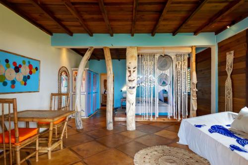 a room with a bed and a table and chairs at La Plage de Le Zahir in Nosy Be