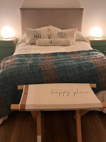 a bed with a sign that says happy place on it at Oeste suites in Mendoza