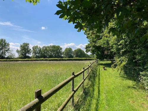 a fence in front of a field of grass at The Stables, Hoo in Woodbridge