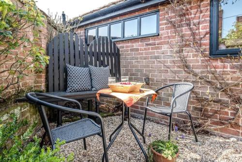 a patio with two chairs and a table at The Stables, Hoo in Woodbridge