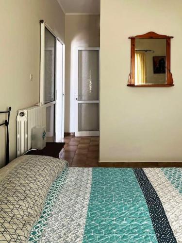 sypialnia z łóżkiem i lustrem na ścianie w obiekcie Andros escape - a cosy 1bed flat w mieście Gavrion