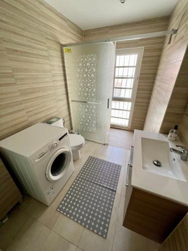 a bathroom with a washing machine and a sink at "Flora B&B "- Rooms in Privat Home Habitaciones en una casa privada in Maspalomas