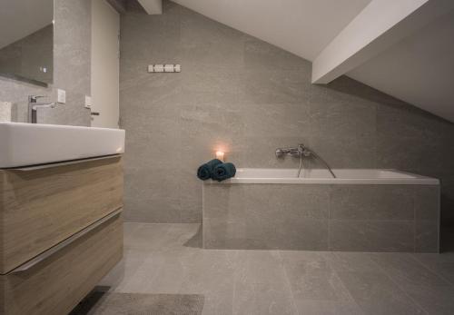 een badkamer met een wastafel en een bad bij Venez Chez Vous - Chalet de Bredanne - Bord du lac in Doussard
