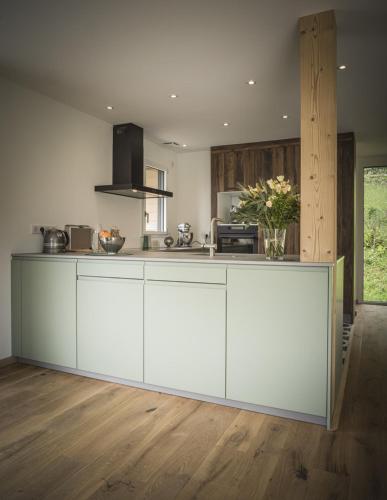 une cuisine avec des armoires blanches et un comptoir dans l'établissement Venez Chez Vous - Chalet de Bredanne - Bord du lac, à Doussard