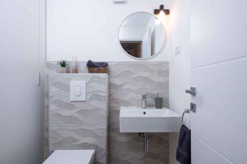łazienka z umywalką i lustrem w obiekcie Holiday home Mali Vareski/Istrien 8734 w mieście Mali Vareški