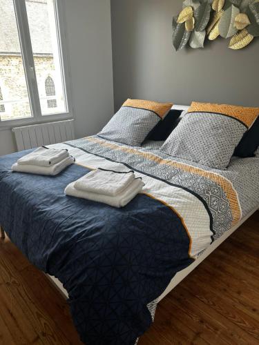 a bedroom with a bed with two pillows on it at leBel endroit 145m2 , terrain et terrasse de 350m2 au coeur des commerces ,à proximité de la mer et tous services inclus in Portbail